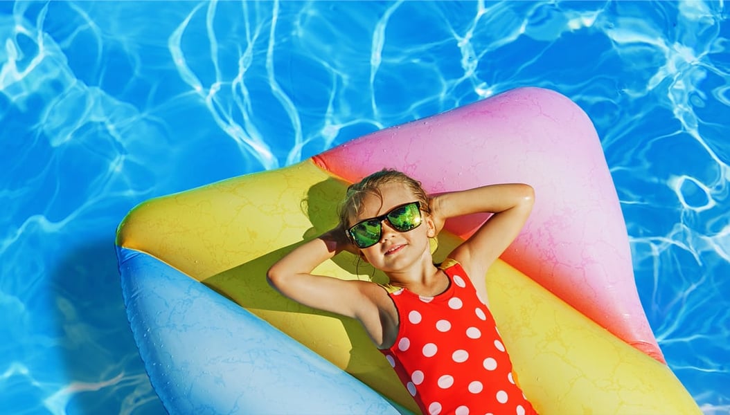 Little girl in bathing suit on pool float with promotional details