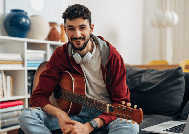 young adult male with guitar in lap