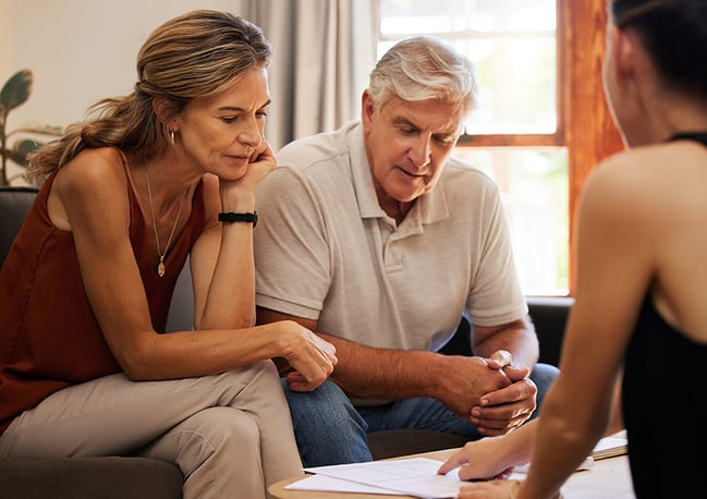 Older couple looking at investment paperwork with a financial advisor. 